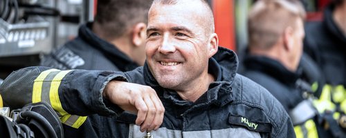 Ein Feuerwehrmann in Einsatzkleidung während einer Pause.