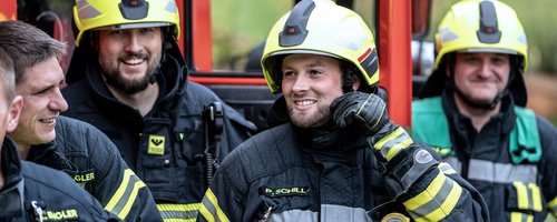 Feuerwehrleute in Einsatzkleidung bei einer Besprechung
