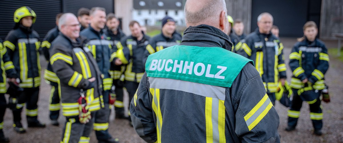 Feuerwehrmann in Uniform gibt Anweisungen an sein Team während einer Einsatzbesprechung.
