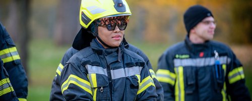 Feuerwehrleute in Einsatzkleidung bei einer Übung im Freien