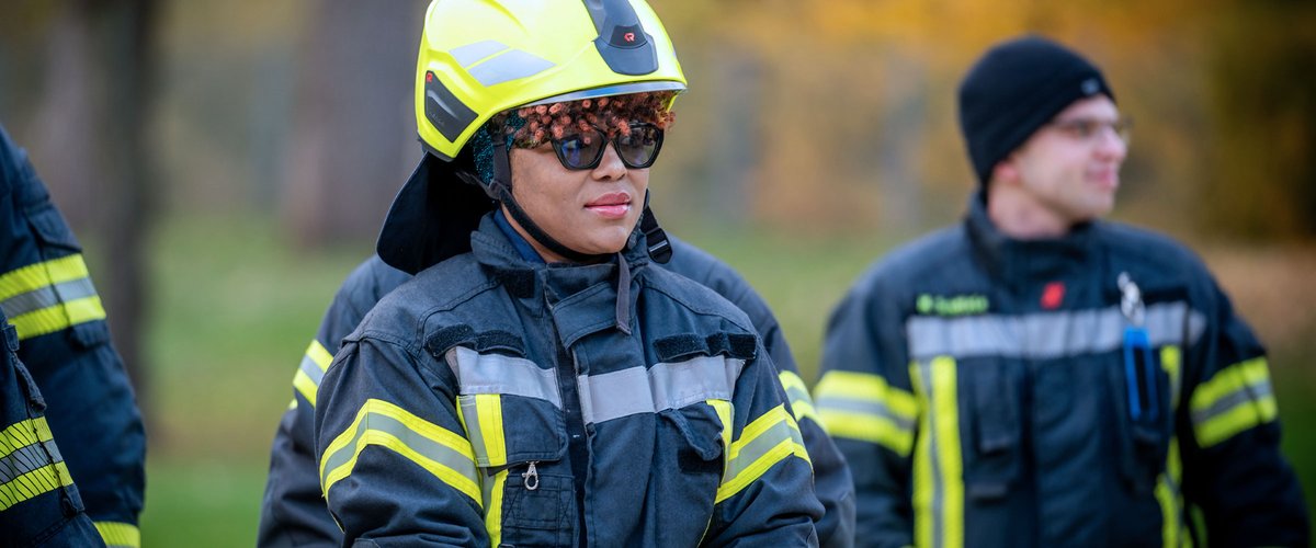 Feuerwehrleute in Einsatzkleidung bei einer Übung im Freien