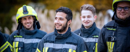 Gruppe von Feuerwehrleuten in Einsatzkleidung im Freien