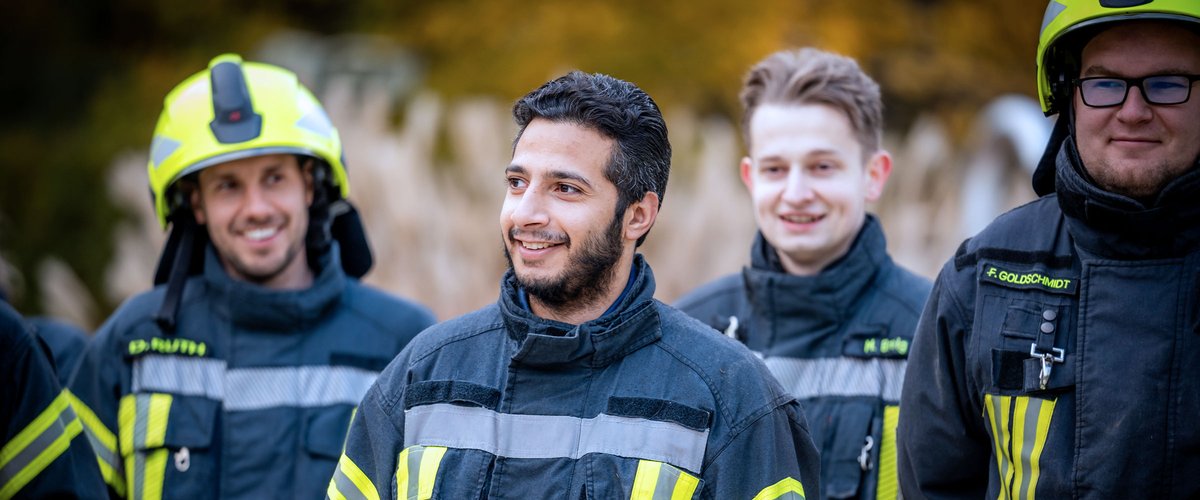 Gruppe von Feuerwehrleuten in Einsatzkleidung im Freien