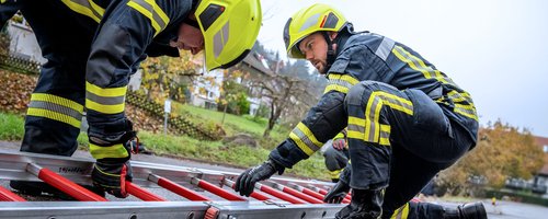 Feuerwehrleute beim Aufstellen einer Leiter im Einsatz