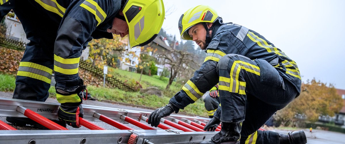 Feuerwehrleute beim Aufstellen einer Leiter im Einsatz